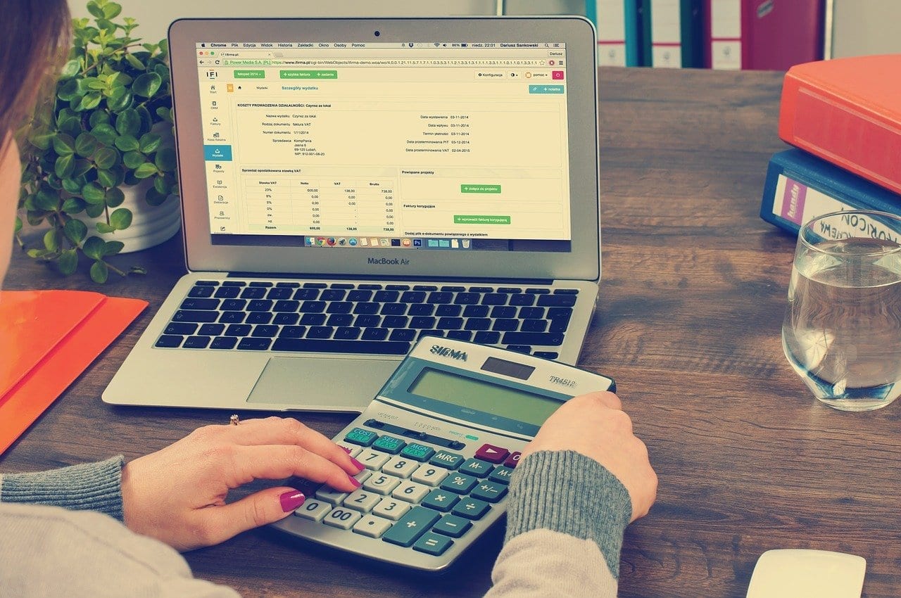 woman on her laptop with a calculator in her hand