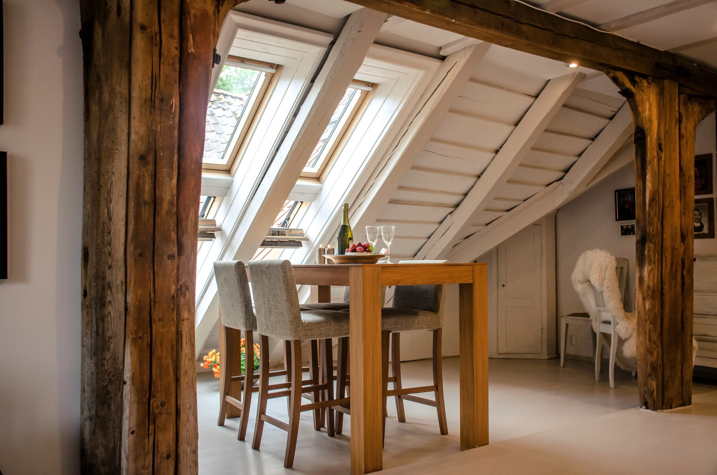 Contemporary dining area in loft conversion space with wooden flooring and ambient lighting by Cowleys interior design specialists