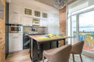 kitchen area with white cabinetry and glass panel